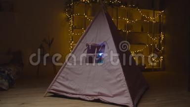 小女孩在帐篷里玩手电筒