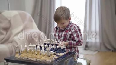 聪明的白人男孩把棋子放在船上的肖像。 小可爱的孩子开始玩不可辨认的游戏