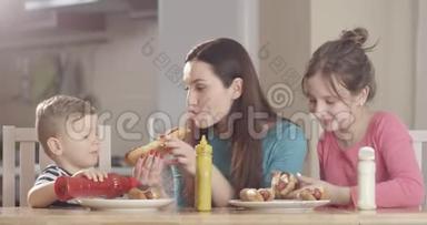 家庭在厨房餐桌上准备热狗和享受食物，在红相机上拍摄美好时光