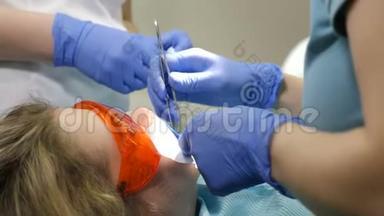 牙科诊所的概念。 看牙医检查年轻家庭病人的<strong>俯视</strong>图。 特写<strong>镜头</strong>。 医生和助理的合作