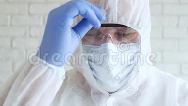 医生在医院隔离时，穿戴手套、口罩和眼镜，安排他的防护服
