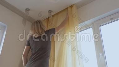 一个女人在打<strong>扫房子</strong>的时候，把薄纱挂在窗户上