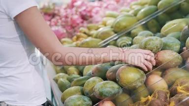 近点，女人在超市挑选芒果水果，比较拿