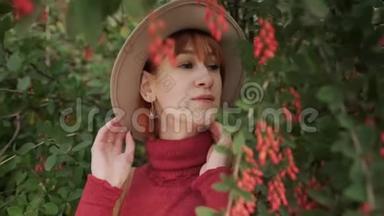一个年轻迷人的红发女孩，一头短发戴着帽子，在一个自然公园里穿着一件兵马俑毛衣。