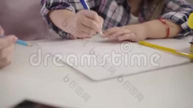 作业本中幼儿手画线条的特写.. 坐在桌子旁做作业的女学生