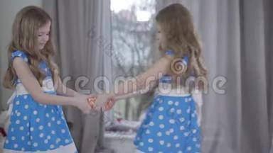 侧视两个小女孩争着要<strong>礼物</strong>.. 穿着优雅蓝色连衣裙的布鲁内特双胞胎<strong>抱</strong>着<strong>礼物</strong>