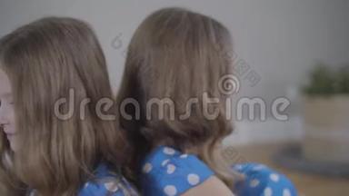 镜头从左到右围绕着两个<strong>相同</strong>的双胞胎姐妹穿着类似的蓝色虚线连衣裙。 布鲁内特姐妹