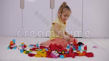 小女孩坐在地毯上玩五颜六色的乐高积木