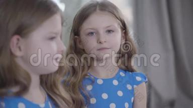 可爱严肃的白人<strong>女孩</strong>的<strong>头像</strong>，灰色的眼睛看着镜头，模糊的双胞胎姐妹的轮廓。