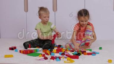 孩子们坐在地毯上玩五颜六色的乐高积木