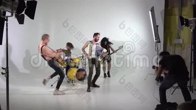 拍了一个朋克摇滚乐队的片段。 一个摄影师在工作。 音乐家们正在用乐器跳跃。 低音