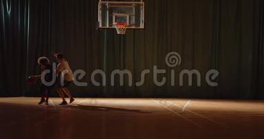 两名篮球青年队员打篮球比赛，防守，进攻，夜间比赛，黑暗