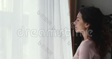 幸福乐观的年轻女子打开窗帘花边透过窗户