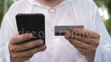男子使用黑色智能手机及支付卡