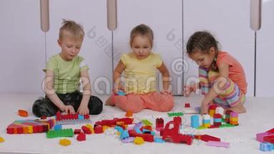 孩子们坐在游戏室的地毯上，玩建造者<strong>乐高积木</strong>