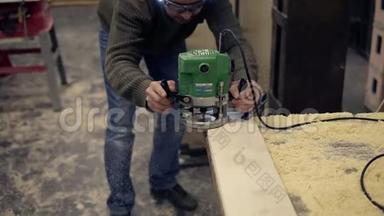 戴防护眼镜的男木工工打磨木条.. 手工打磨机在