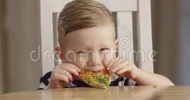 小男孩吃比萨饼享受品味和微笑的肖像拍摄红相机