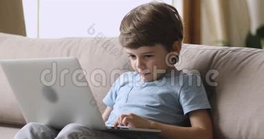 沉迷于<strong>科技</strong>快乐的<strong>小</strong>男孩在笔记本电脑上玩游戏。