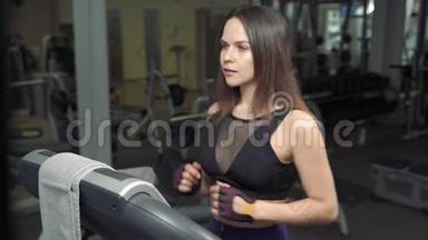 健身妇女在健身房跑步<strong>机</strong>上做有氧训练。 健身中心的运动女孩使用跑步<strong>机</strong>