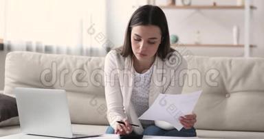 年轻女人用计算器计算账单