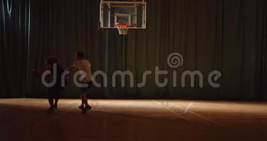 两名年轻的<strong>篮球</strong>运动员<strong>打篮球</strong>比赛，防守，进攻，夜间比赛，黑暗的轮廓