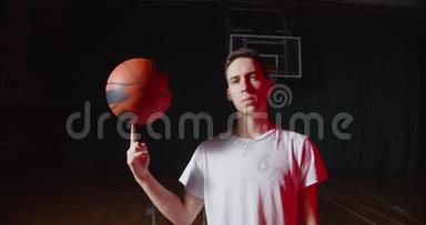 特写白种人青年篮球运动员肖像红光光束黑色暗篮背景与球