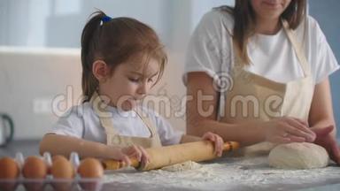 <strong>妈妈帮</strong>女儿在厨房里卷面团来烤饼干。 <strong>妈妈</strong>和女儿一起在厨房里烤披萨。 女孩