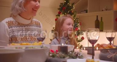 小白种人女孩孙女带着祖母圣诞晚餐家庭微笑