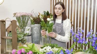 年轻女子花店检查和选择最好的花束在车间或花店。