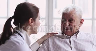 微笑健康的老爷爷和有爱心的年轻女医生交谈