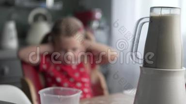 一个小女孩从厨房里一个工作搅拌机的噪音中插入耳朵。