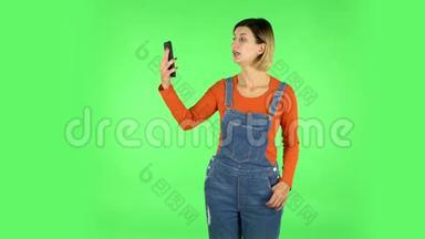 女孩用手机聊天视频。 绿色屏幕