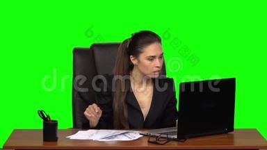 在笔记本电脑上工作的女孩突然开始在桌子上寻找文件，当她发现时，她松了一口气。 绿色