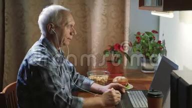 晚上，一位戴着耳机的老人在视频连线上讲话，他用笔记本电脑向对话者伸出大拇指