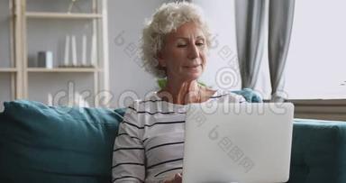 快乐的老奶奶用电脑，独自坐在客厅里。