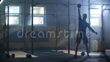 健身男子在健身房进行功能训练时做哑铃<strong>抓举</strong>运动。 慢动作。