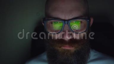 戴眼镜的胡子男深夜浏览网站，眼镜反光
