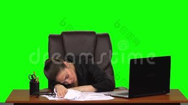 疲惫的商务小姐把头放在桌子上，重重地叹了口气。 绿色屏幕。 工作室。 慢动作