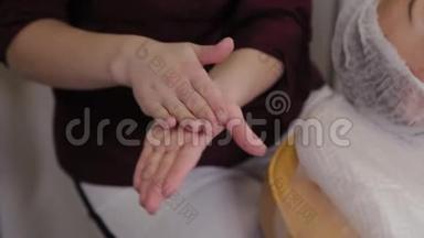 一位戴橡胶手套的护士在她的手上喷洒消毒剂，特写。 护士喷出手消毒剂溶液。