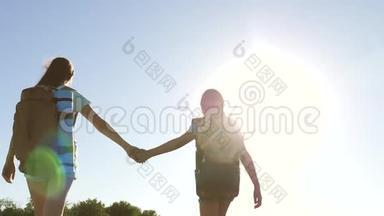 团队合作游客青少年。 女旅行者走在农村的一条路上。 夏天公园里快乐的徒步旅行者女孩。 快乐