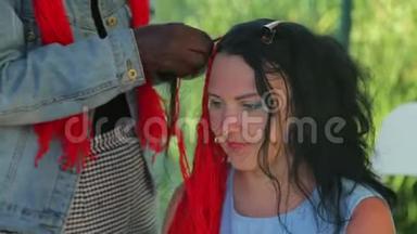 一个年轻的犹太女人用<strong>红线</strong>编织辫子，一个皮肤黑的女孩