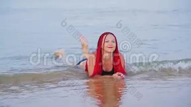 一个穿着<strong>红色</strong>辫子的黑色泳衣的女人躺在<strong>海边</strong>的海水里