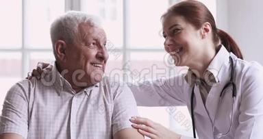 关爱年轻女医生护理员帮助支持快乐的老人