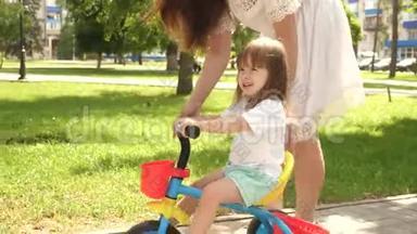 孩子学会骑自行车。 幸福家庭和<strong>童年的</strong>概念。 父母和小女儿在公园散步。 快乐