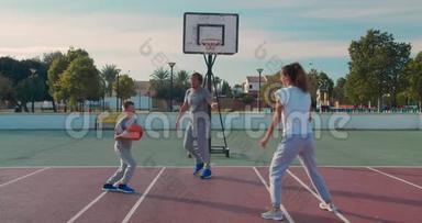 一家人在户外球场打篮球。
