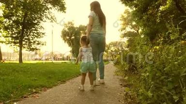 小女儿和妈妈牵着手走着小路。 宝贝牵着妈妈`手。 妈妈和宝宝在公园休息。 a的概念