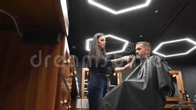 理发店的女理发师用理发刀给留胡子的男人理发。男士发式及沙龙理发。梳毛
