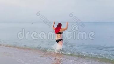 一个穿着<strong>红</strong>色<strong>辫子</strong>的黑色泳衣的女人从岸上的海里出来
