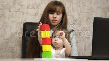 妈妈在办公室里和她<strong>的</strong>孩子在<strong>工作</strong>时用多种颜色<strong>的</strong>立方体玩耍。 <strong>忙碌的</strong>女人拿着婴儿在<strong>工作</strong>