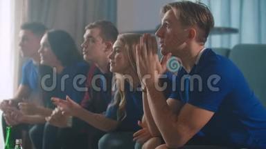 情绪，球迷在电视上兴奋地观看足球比赛，然后为胜利坐在沙发上而欢欣鼓舞